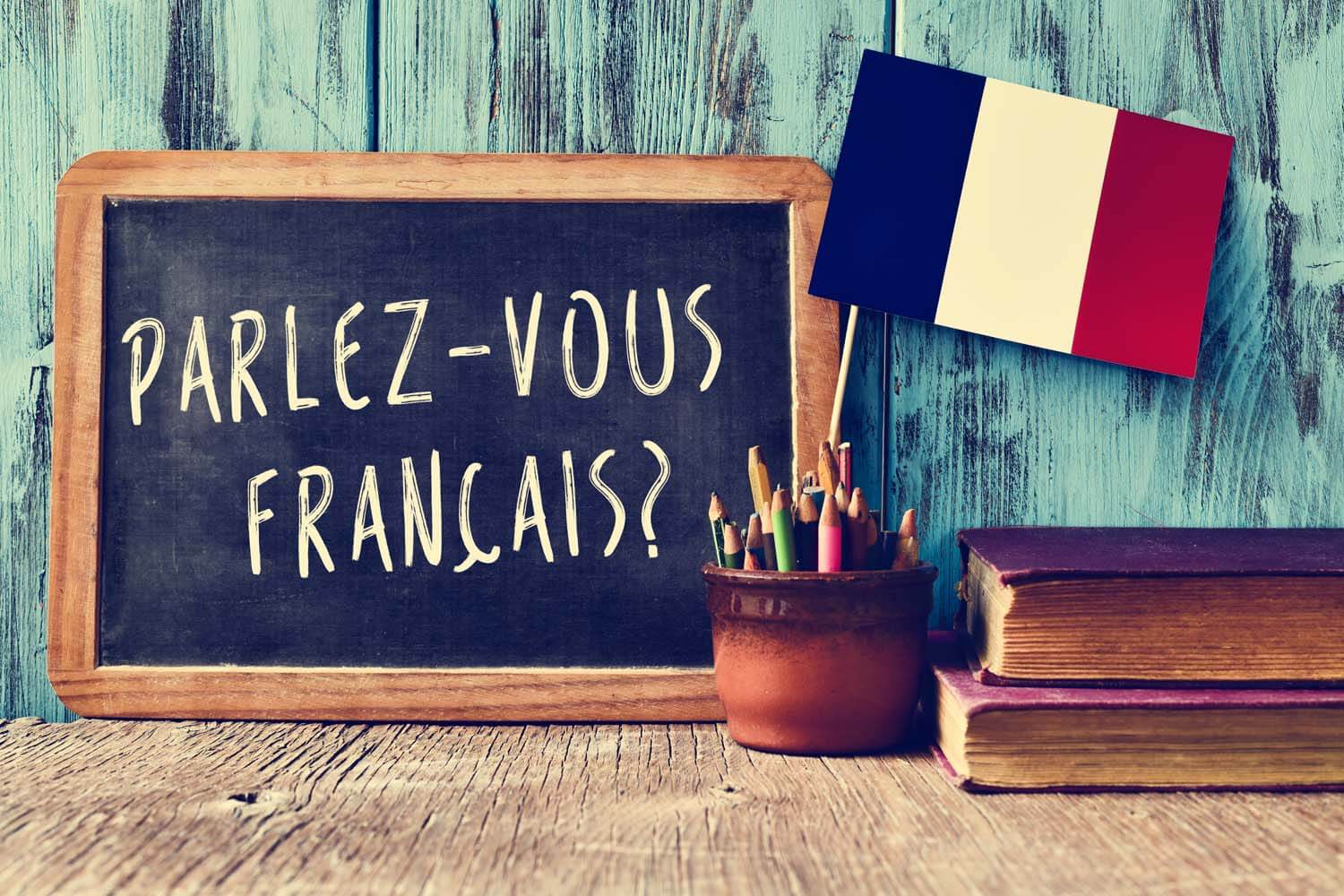 A chalkboard reading “Parlez-vous français ?” next to a French flag