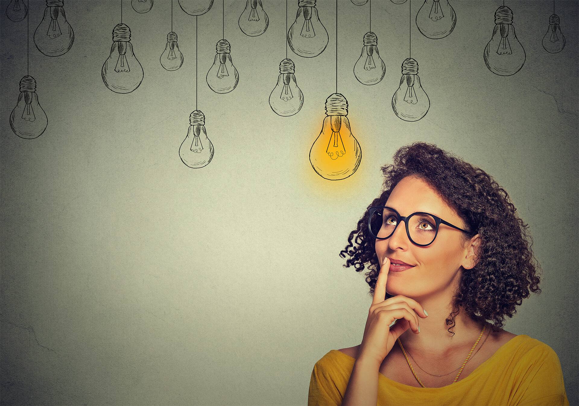 A woman thinking, surrounded by light bulbs